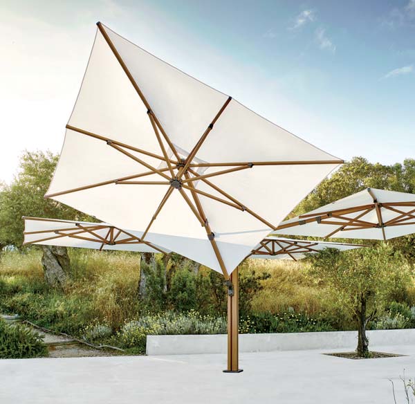 Large outdoor umbrella in a garden setting with trees and sky in the background