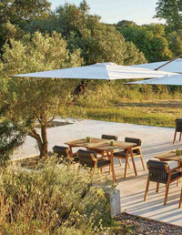Outdoor patio with wooden furniture and canopy in a natural setting