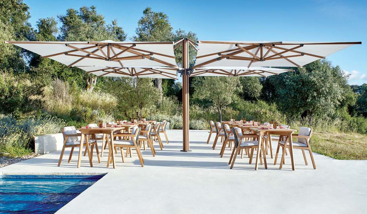 Outdoor dining area with tables, chairs, and a large umbrella providing shade.