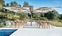 Outdoor dining area with tables, chairs, and a large umbrella providing shade.