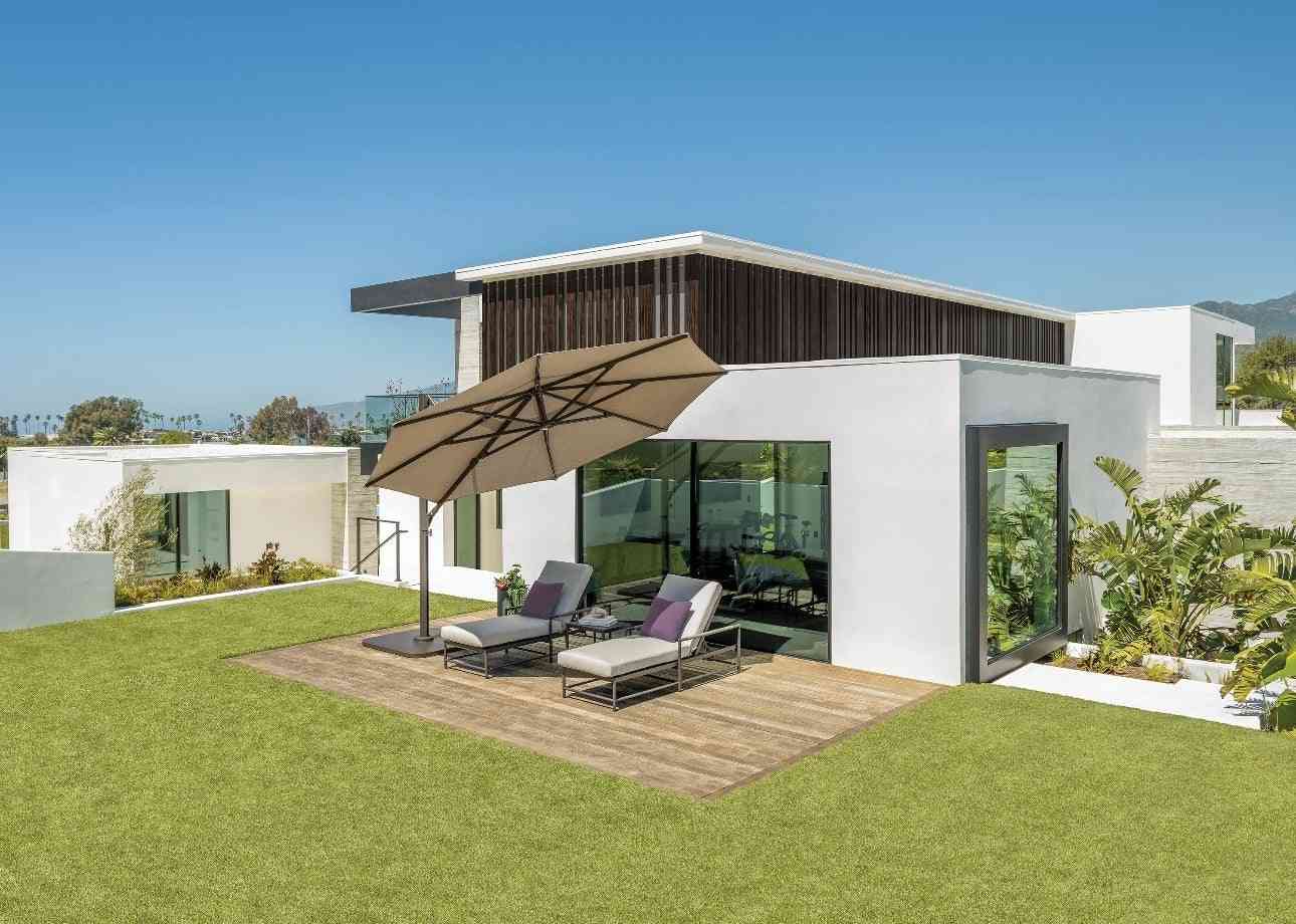Modern house exterior with patio furniture and umbrella