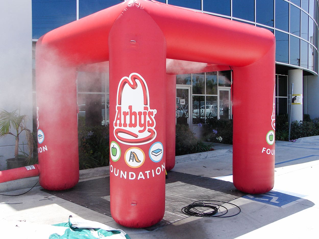 Red inflatable arch with Arby's Foundation logo in front of a building.