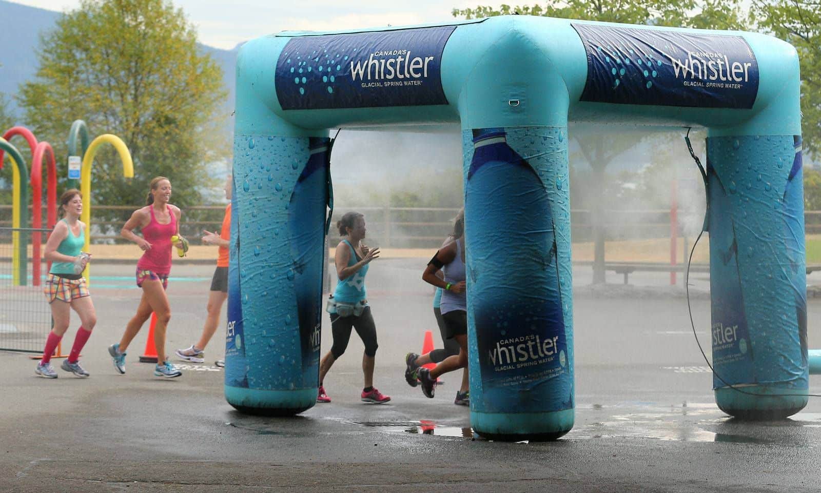 Inflatable Whistler race arches with runners in a park setting