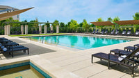 Pool area with lounge chairs and a clear blue sky
