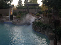Backyard pool with water feature and evening sky