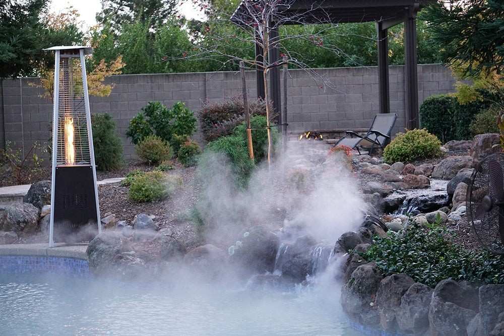 Outdoor setting with a pool, water feature, and patio heater in a garden.