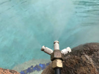 Metal valve or connector on a rock with water in the background