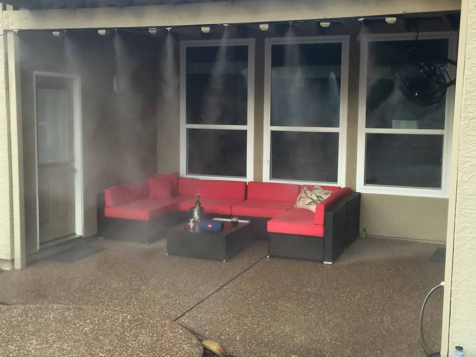 Red and black outdoor furniture set with misters on a patio