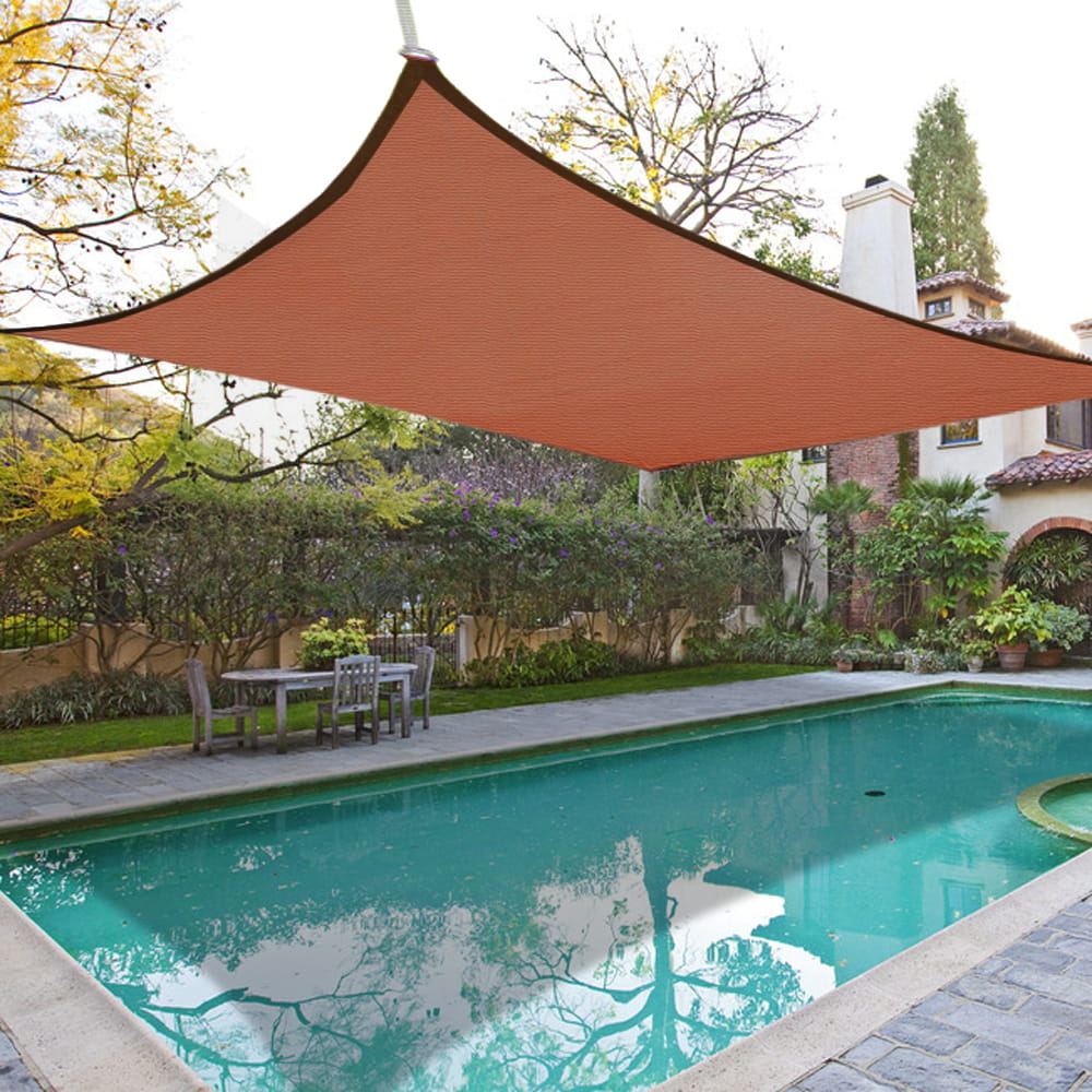 Orange sunshade over a pool area with a garden and house in the background