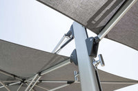 Close-up of a large outdoor umbrella with a gray canopy and metal frame against a clear sky.