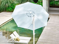 Large patio umbrella over a lounge chair by a poolside