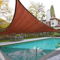 Brown triangle-shaped pool cover over a swimming pool with a patio and trees in the background